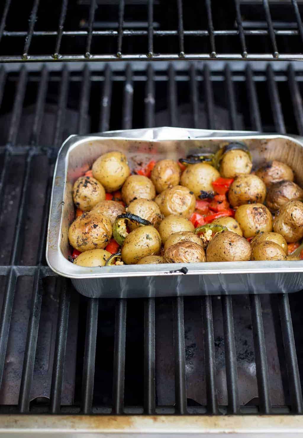 These nacho bowls are SO easy! Grilled potatoes covered with beans, corn, jalapenos and a creamy chipotle sauce. Vegan and Gluten-Free. | www.delishknowledge.com 