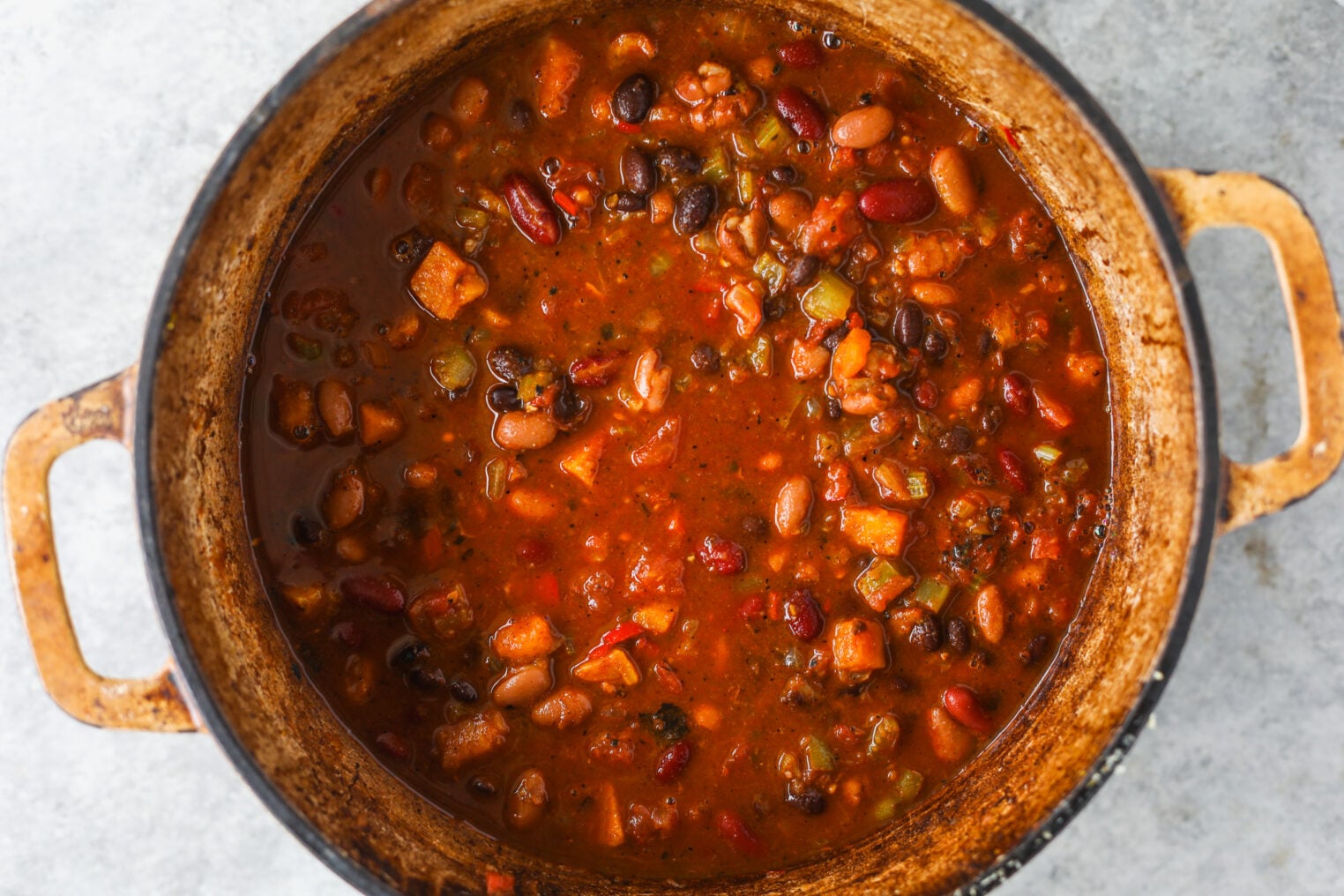 A Dutch Oven Filled With A Hearty Vegetarian Chili Made With Beans And Vegetables.