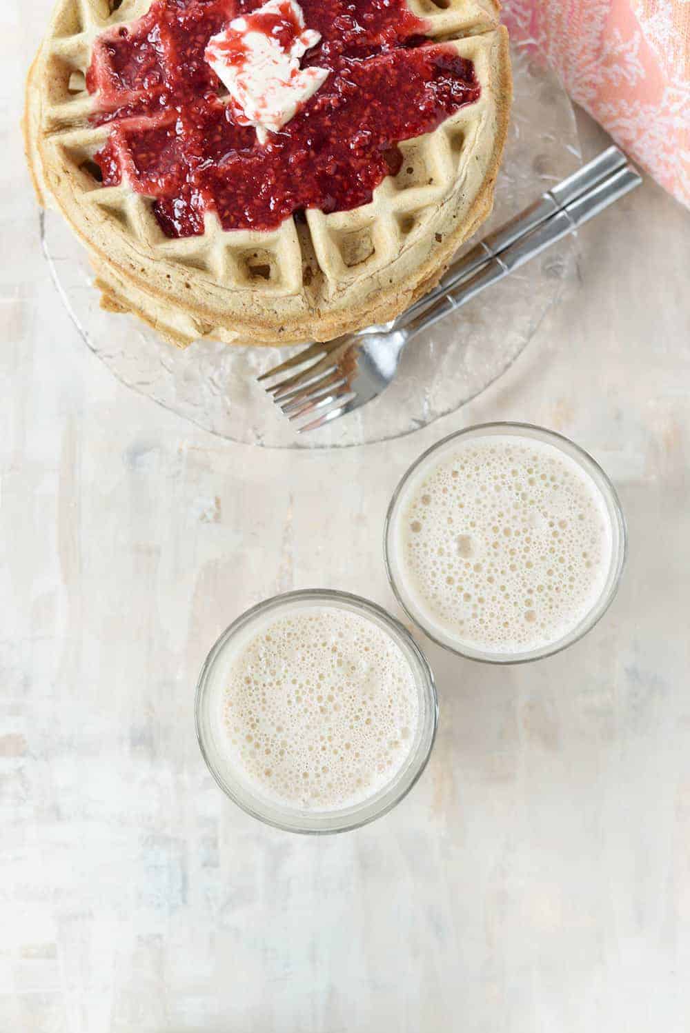 two cups of chai cashew lattes with whole wheat freezer waffles and raspberry jam