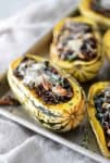 Wild Rice, Kale and Cranberry Stuffed Delicata Squash. The perfect vegetarian main dish. Roasted Squash stuffed with wild rice, kale, pecans, cranberries and topped with cheese. Gluten-free | www.delishknowledge.com
