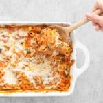 Serving the pasta bake with a wooden spoon
