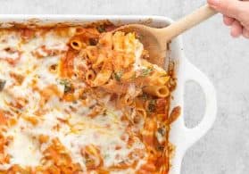 Serving the pasta bake with a wooden spoon