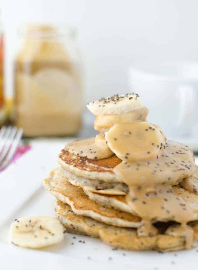 Vegan Chia Pancakes Topped With Velvety, Decadent Maple-Peanut Butter Syrup And Fresh Sliced Bananas!