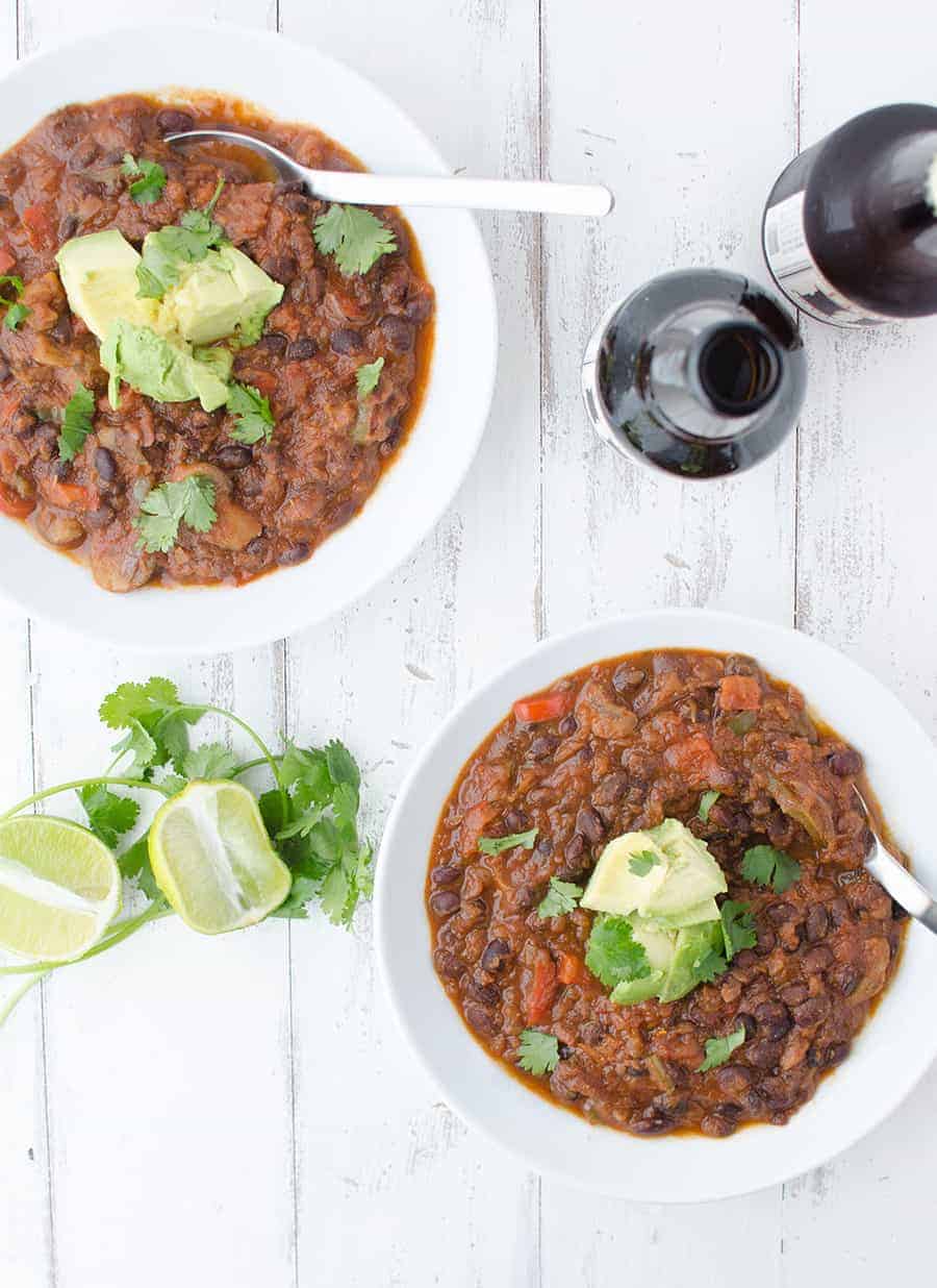 Black Bean & Beer Chili! A hearty vegetarian chili loaded with mushrooms, beans, peppers and simmered in a tangy beer sauce. 17g fiber and 22g protein in every bowl| www.delishknowledge.com