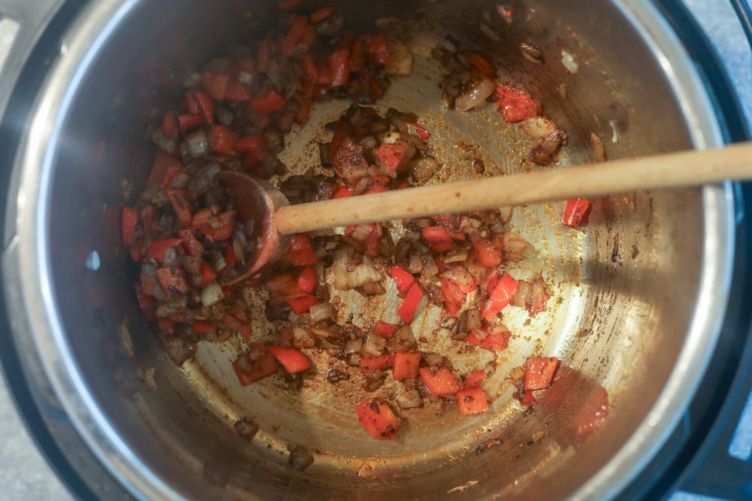 Slow Cooker Black Bean Chili with Butternut Squash 3 Chopped Red Bell Peppers And Onions Sautéing In A Metal Pot, Stirred With A Wooden Spoon. These Veggies Form The Flavorful Base For A Hearty Slow Cooker Black Bean Chili, With Browning Adding Depth To The Final Dish.