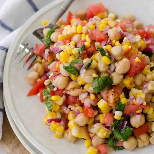 Corn, Tomato And Mint Salad! This Gluten-Free, Vegan Side Dish Is Perfect For Summer! Juicy Tomatoes, Fresh Corn, Onion, Chickpeas And A Lemon Mint Dressing. High-Fiber And Full Of Protein! | Www.delishknowledge.com