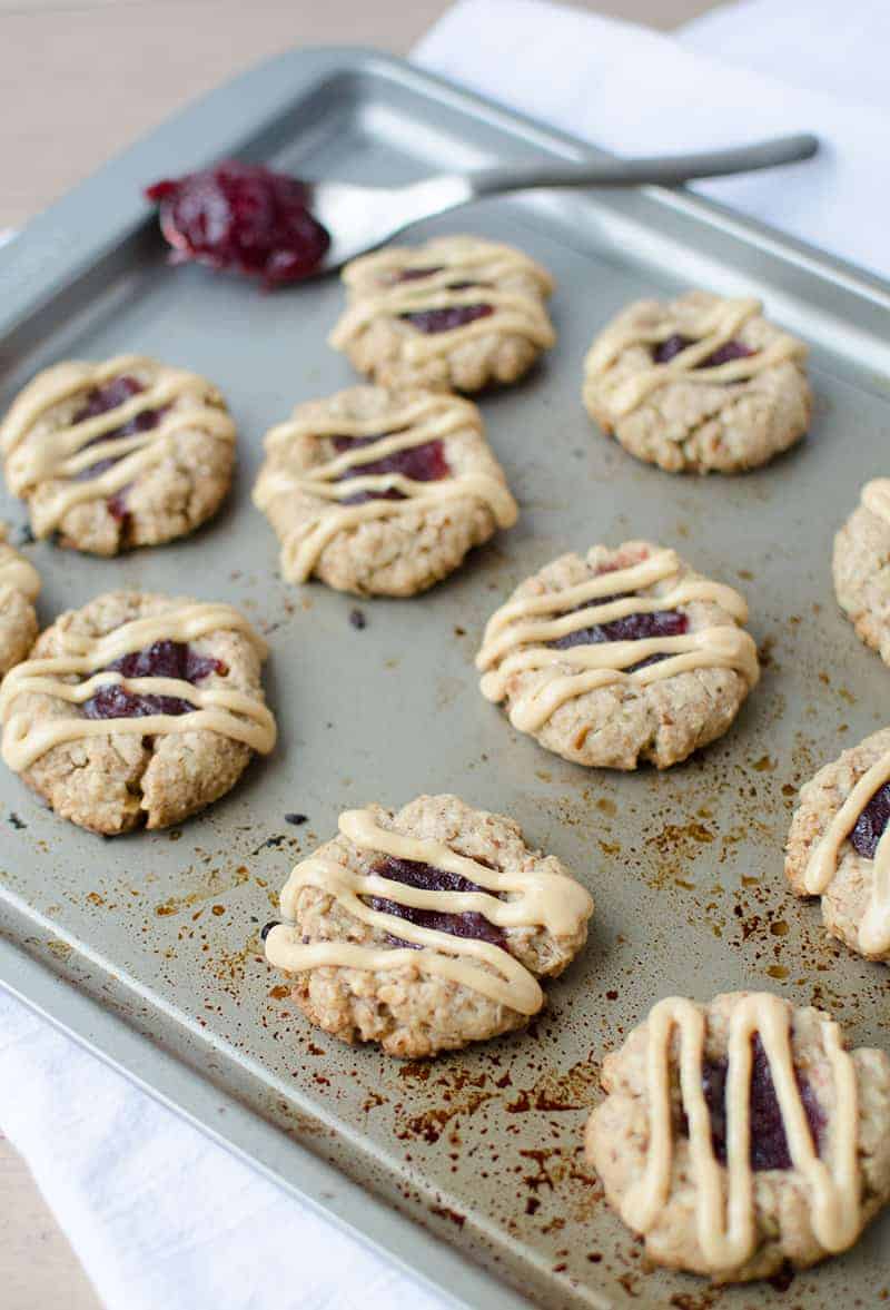 Thumbprint Cookies! Pecan Cookies Topped With Cranberry Jam And Peanut Butter Drizzle. Wholesome, Naturally Sweetened And Vegan! | Www.delishknowledge.com