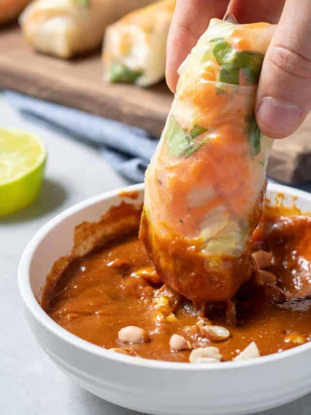 Dipping Vietnamese Spring Roll Into Spicy Peanut Sauce
