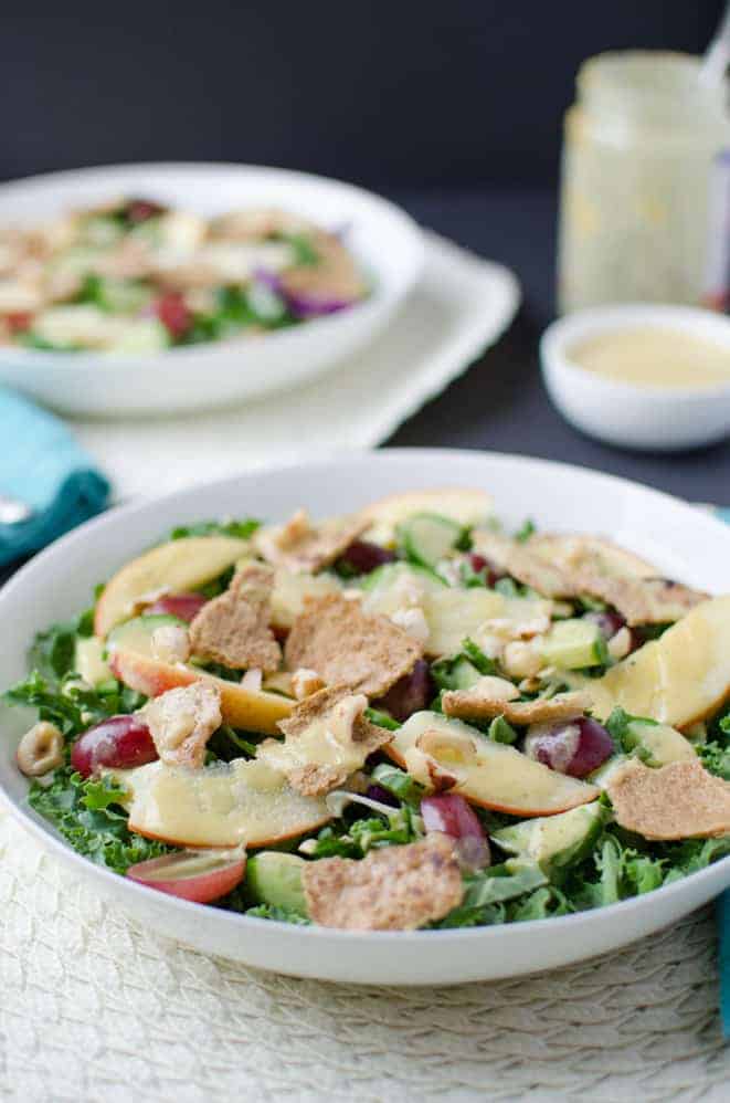 Fall Fattoush Salad! Kale salad tossed with sliced apples, juicy grapes, maple-mustard dressing and topped with pita chips. Vegan and Gluten Free.