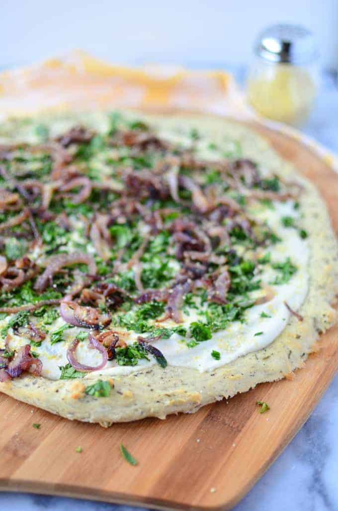 The Best Dairy-Free Pizza! Herb And Garlic Crust Topped With Creamy White Sauce, Caramelized Onions, Fresh Herbs And Vegan Parm Sprinkle. 