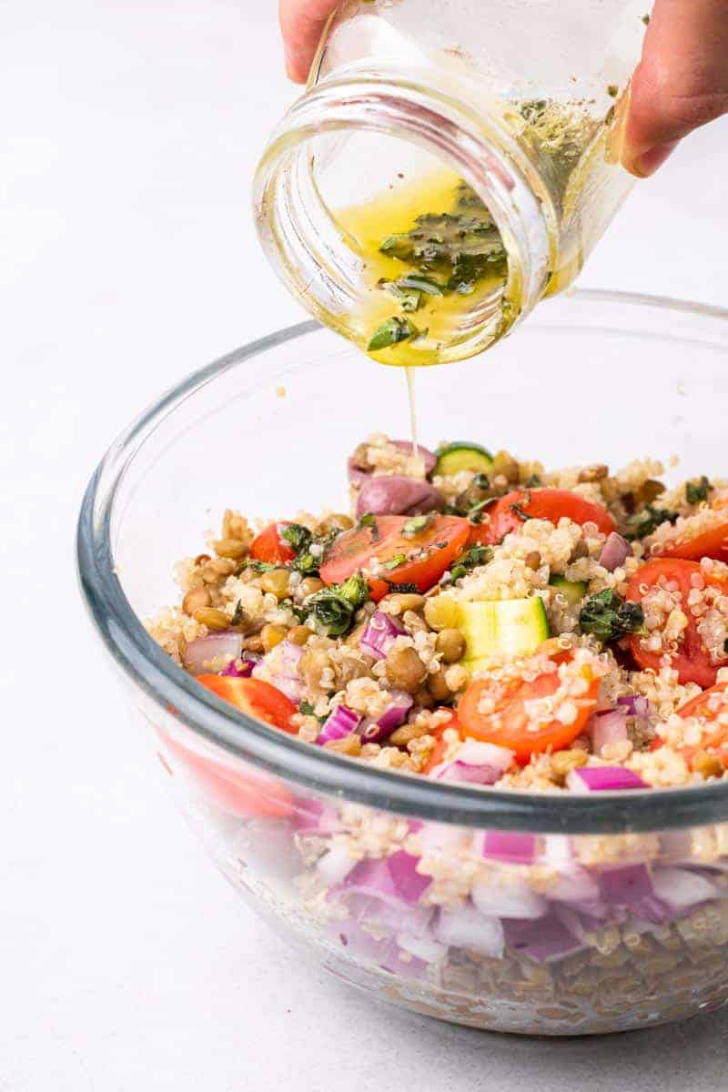 Dressing Being Poured On Greek Lentil Salad