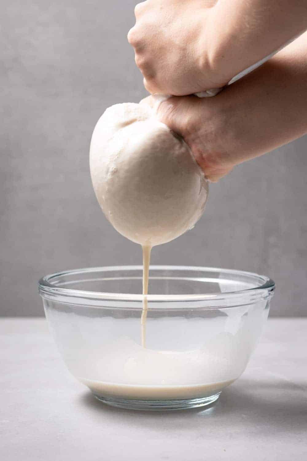 How to Make Oat Milk 4 Oat Milk Being Strained Through Nut Milk Bag