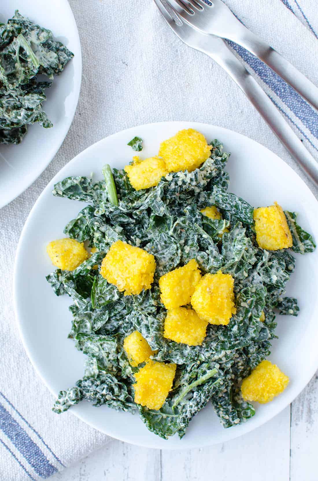 Kale Caesar Salad! Creamy caesar dressing with crispy polenta croutons. Vegan & Gluten-Free | www.delishknowledge.com