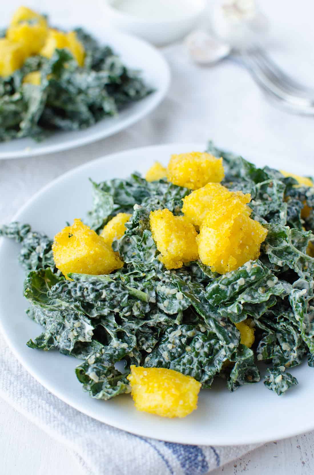 Kale Caesar Salad! Creamy caesar dressing with crispy polenta croutons. Vegan & Gluten-Free | www.delishknowledge.com