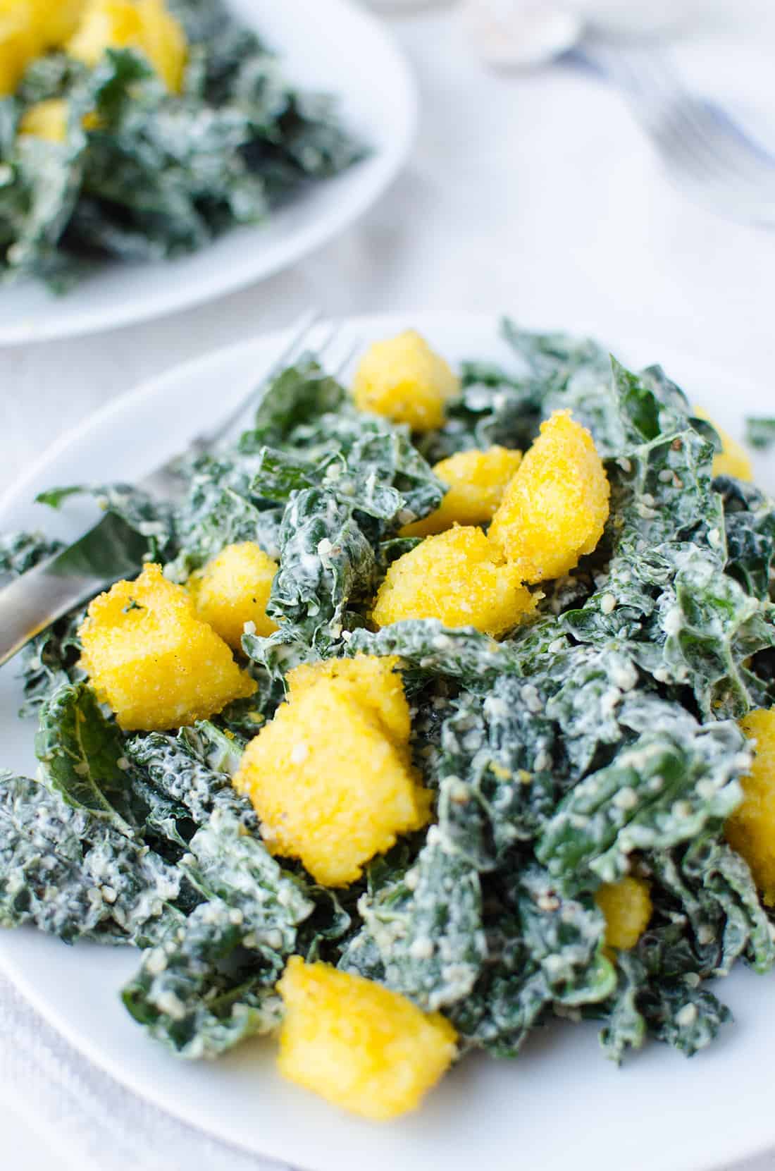 Kale Caesar Salad! Creamy caesar dressing with crispy polenta croutons. Vegan & Gluten-Free | www.delishknowledge.com