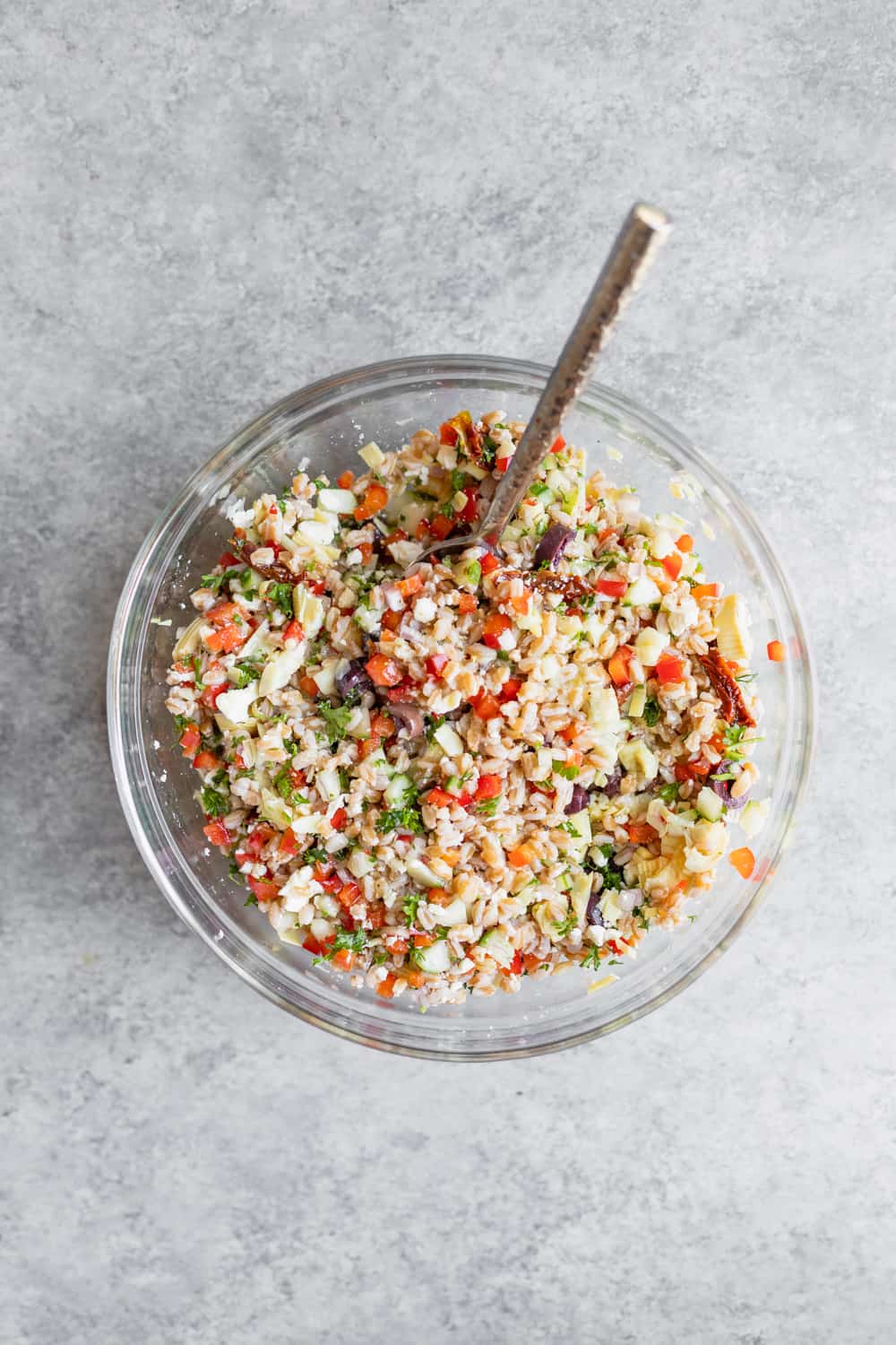 Farro Salad with a spoon in a glass bowl 