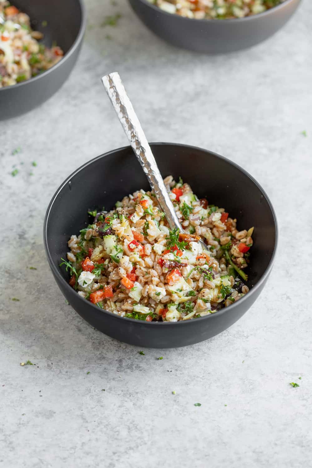 Farro With Tomatoes And Cucumbers In A Black Bowl