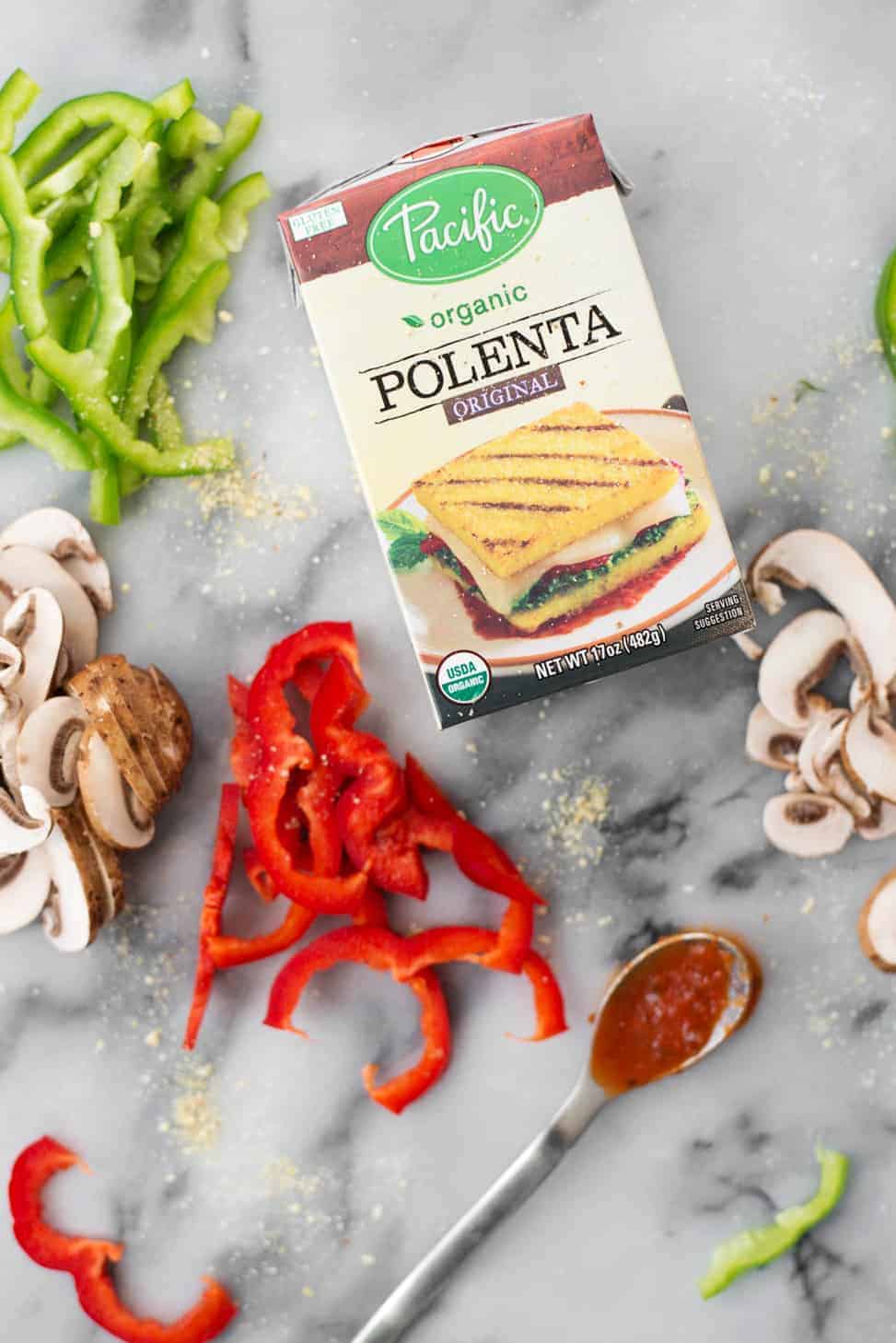 Polenta Pizza! You've got try this unusual twist on pizza. Polenta pizza crust topped with sauce, vegetables and vegan parmesan cheese.| www.delishknowledge.com