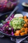 Roasted Butternut Squash Burrito Bowls! You will love these gluten-free and vegan burrito bowls. Roasted and spiced butternut squash cubes, black bean and cabbage slaw with homemade guacamole. Vegan & Gluten-Free | www.delishknowledge.com