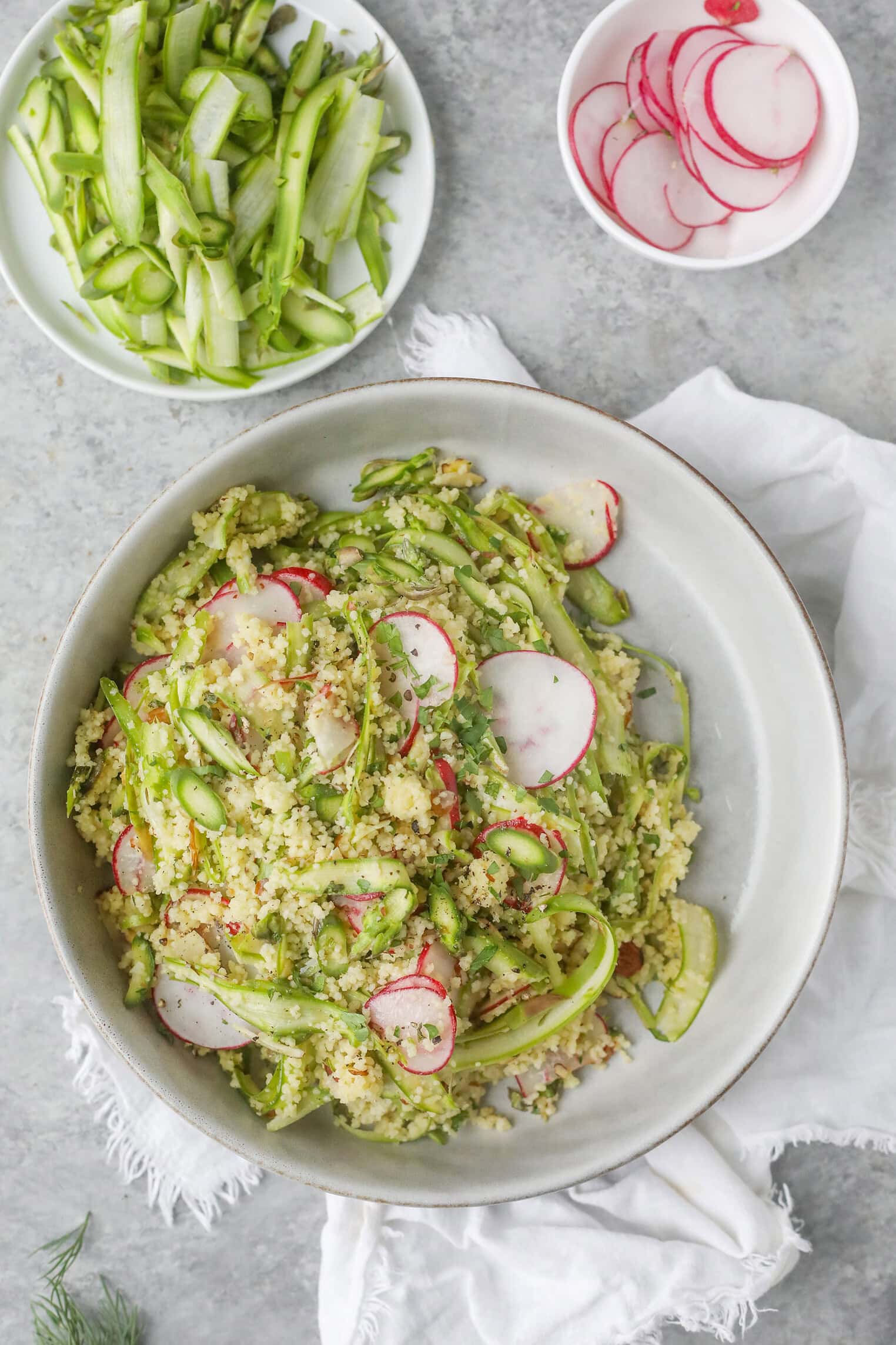 Shaved Asparagus Spring Salad 9 A Bowl Of Quinoa Salad With Sliced Radishes And Shaved Asparagus, Garnished With Herbs. Nearby, A Plate Holds More Shaved Asparagus For This Shaved Asparagus Spring Salad, Plus A Small Bowl Of Extra Radish Slices On A White Napkin.