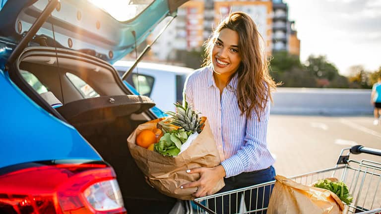 Happy,Woman,Walking,To,The,Car,After,Shopping,At,The