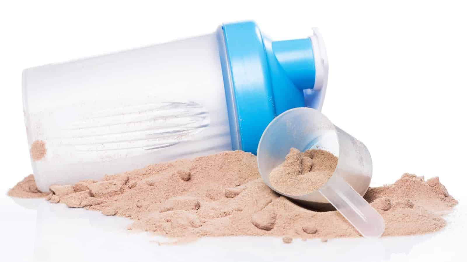 Shaker and protein powder on white background