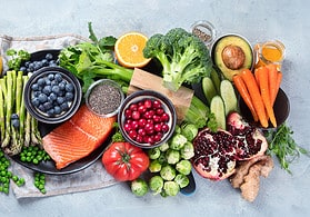 Healthy food selection on gray background. Detox and clean diet concept. Foods high in vitamins, minerals and antioxidants. Anti age foods. Top view