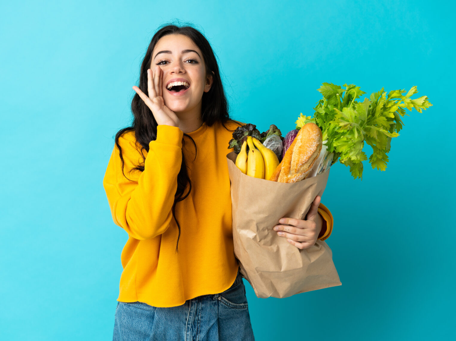Dietitian Explains How to Lower Inflammation with Lifestyle Changes 12 Young,Woman,Holding,A,Grocery,Shopping,Bag,Isolated,On,Blue