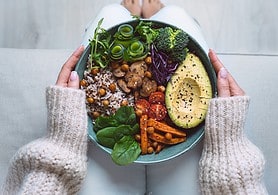 Healthy eating. Plate with vegan or vegetarian food in woman hands. Healthy plant based diet. Healthy dinner. Buddha bowl with fresh vegetables