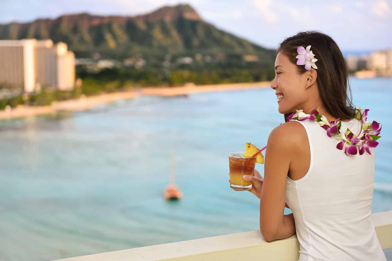 8 Features Every Family Should Look for in an All-Inclusive Resort 7 Hawaiian Woman Drinking Mai Tai In Resort On Waikiki Beach, Hawaii. Beautiful Asian Tourist On Hawaii Travel Looking At Sunset Over Diamond Head Mountain In Honolulu, Oahu, Hawaii Usa.