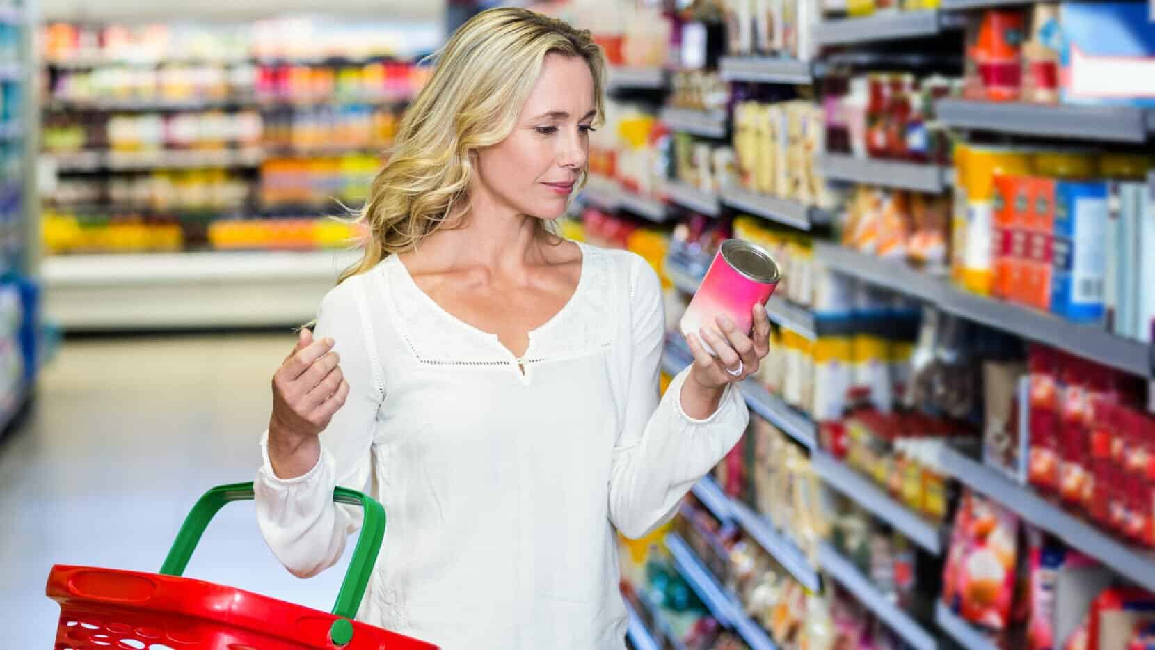 Woman Reading A Can In The Grocery Store