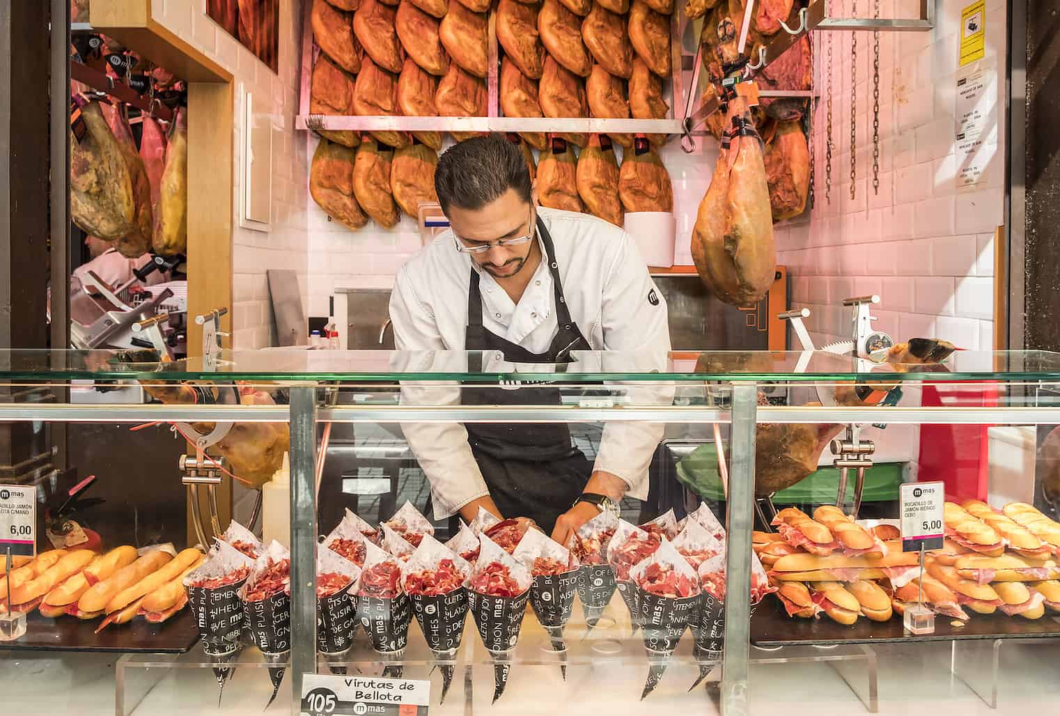 Madrid, Spain - October 7, 2017: Man at a Food Stand Selling Iberico Ham in San Miguel Market