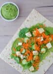 Spinach Hummus! Slightly spicy hummus wrapped into whole wheat lavish bread and topped with veggies and lightly fried tofu. Healthy and filling lunch!
