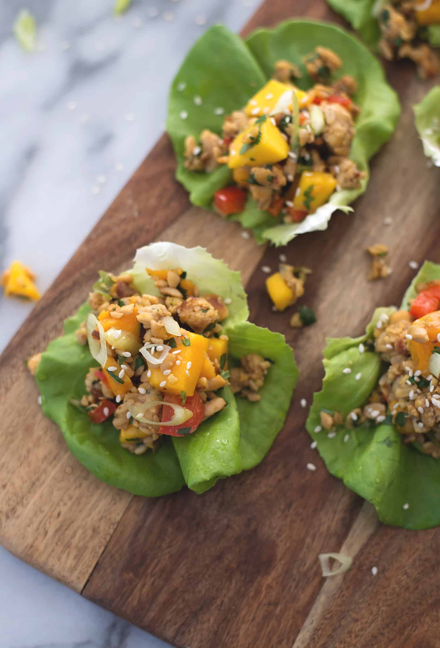 Tempeh Mango Lettuce Wraps! Spicy ground tempeh with peppers and mango, stuffed into butter lettuce cups. Vegan & Gluten-Free | www.delishknowledge.com