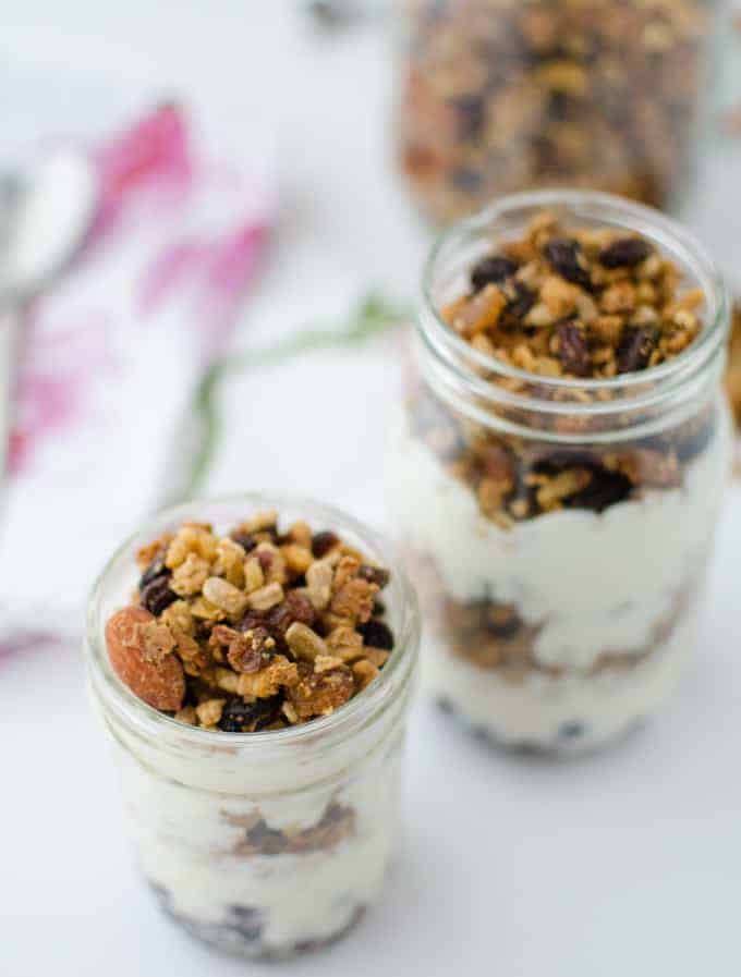 Trail mix granola! Healthy baked granola clusters of almonds, sunflower seeds, and walnuts. Layered in jars with frozen fruit and yogurt for a quick on-the-go breakfast! Vegan or vegetarian; gluten-free
