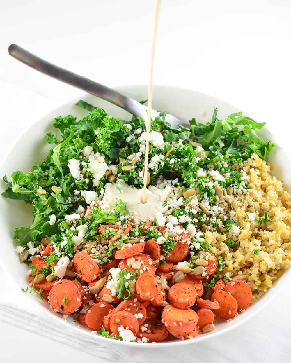 Pouring The Creamy Goddess Dressing Onto The Salad 