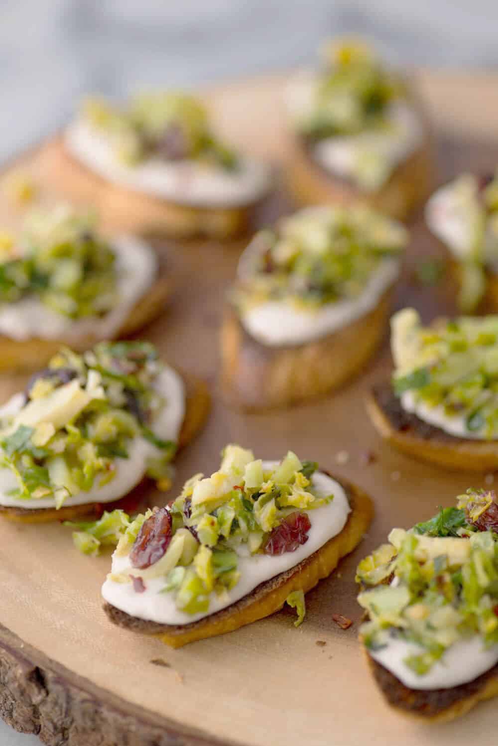 Vegan Brussels Sprout Crostini! Lemon-White Bean Spread topped with charred brussels sprouts and dried cranberry salad. A must-make for the holidays! | www.delishknowledge.com