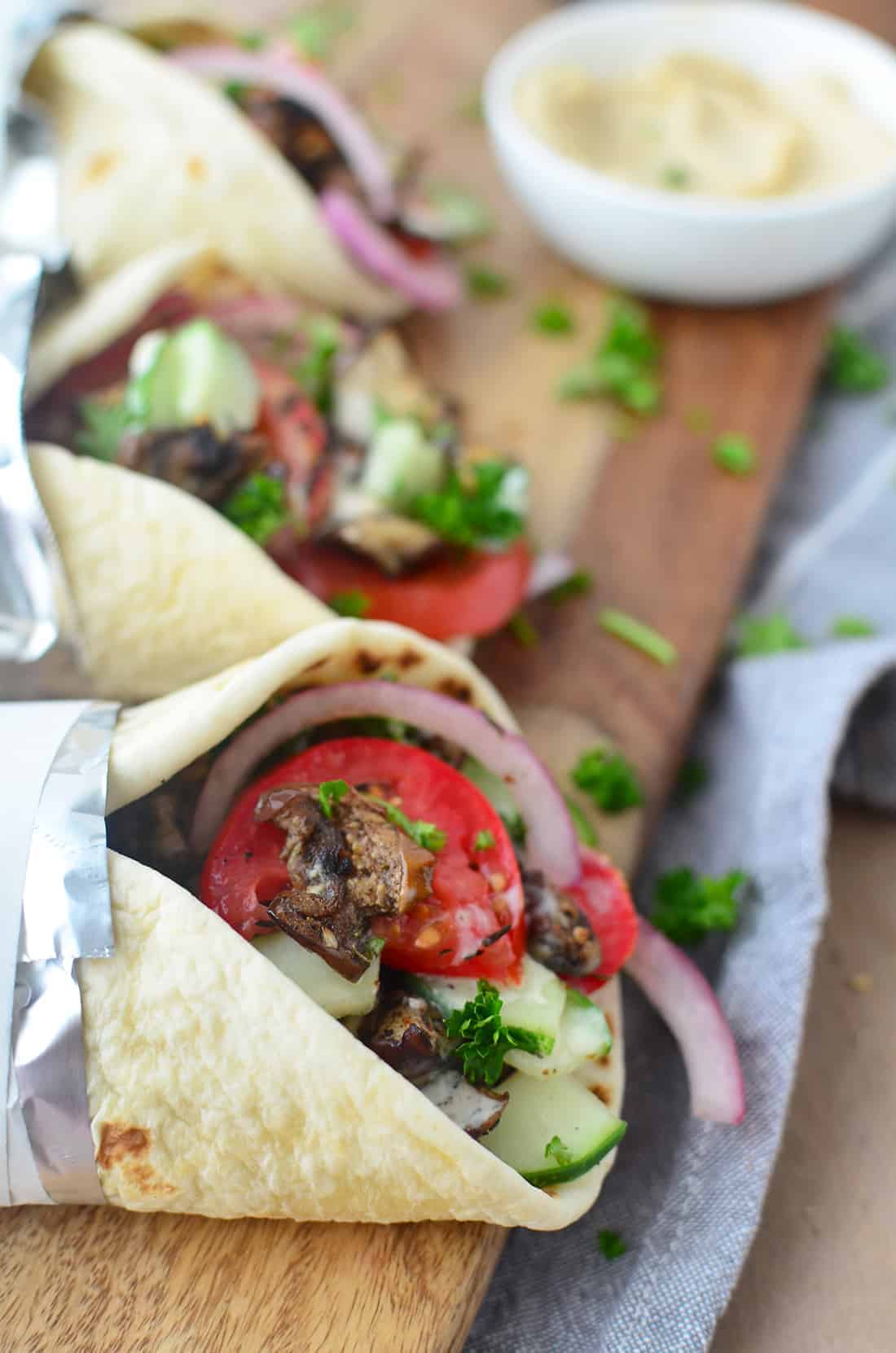 Three Gyro Sandwiches On Cutting Board