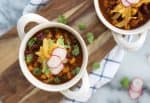 Vegan Pozole! Hearty, protein-rich soup made with hominy, peppers and beans. Vegan and gluten-free | www.delishknowledge.com