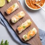 Vietnamese tofu spring rolls on wooden platter with spicy peanut sauce